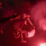 Policemen drag away a person protesting against Israeli Prime Minister